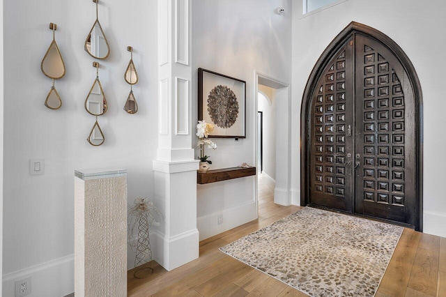 foyer entrance with light hardwood / wood-style floors and a high ceiling