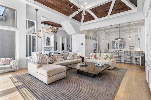 living room featuring ceiling fan, coffered ceiling, beamed ceiling, a towering ceiling, and hardwood / wood-style flooring