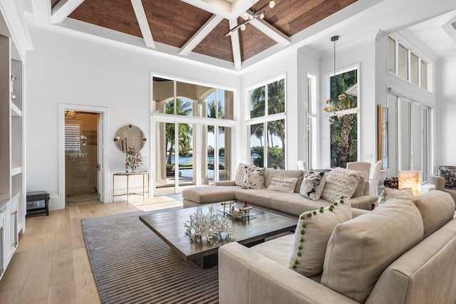 living room featuring ceiling fan, a towering ceiling, wood ceiling, and light wood-type flooring