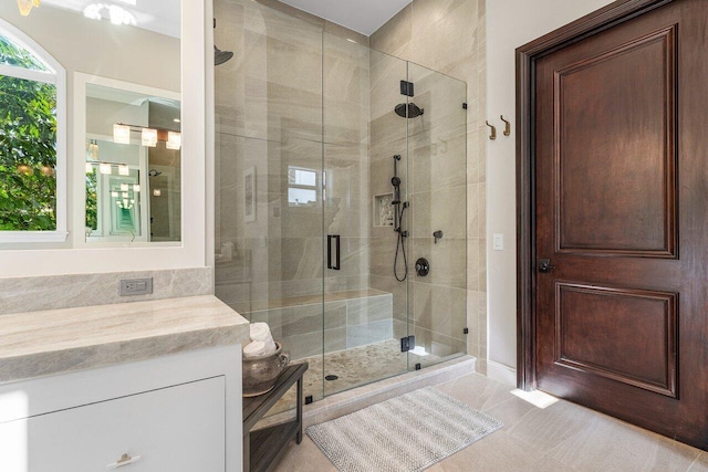 bathroom featuring vanity, tile patterned floors, and a shower with shower door