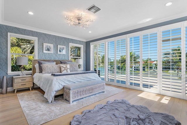 bedroom with access to exterior, light hardwood / wood-style flooring, and multiple windows