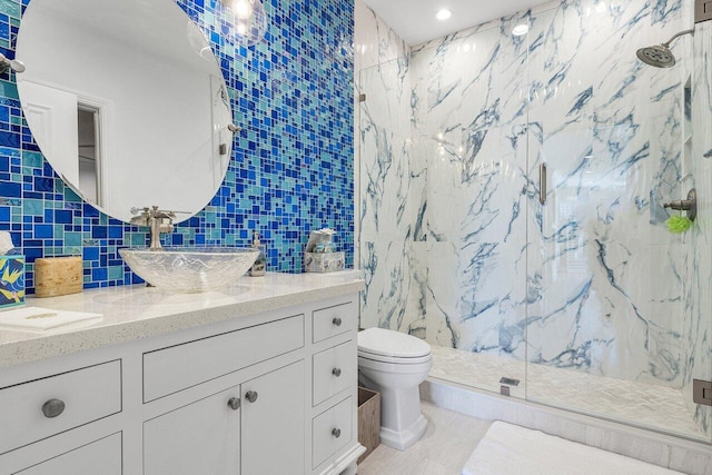 bathroom featuring backsplash, vanity, a shower with door, tile walls, and toilet