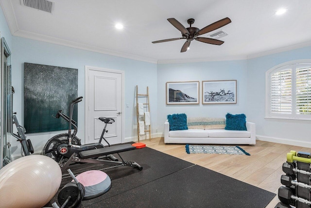 workout area featuring ceiling fan, light wood-type flooring, and crown molding