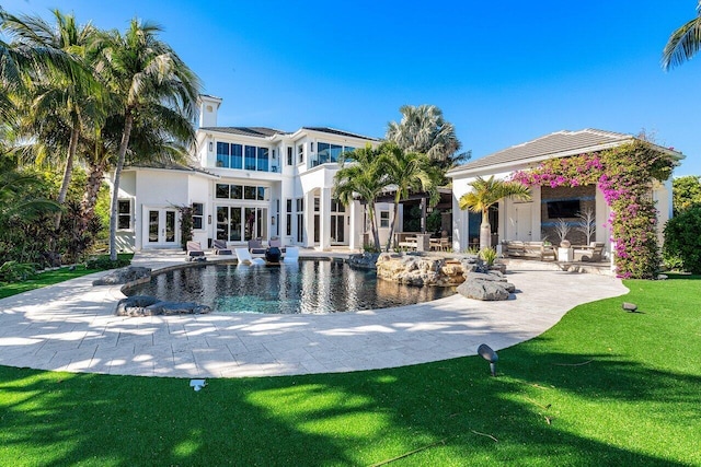 rear view of house featuring a yard, french doors, and a patio