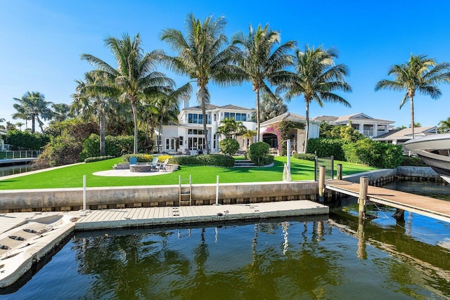 back of property with a lawn and a water view