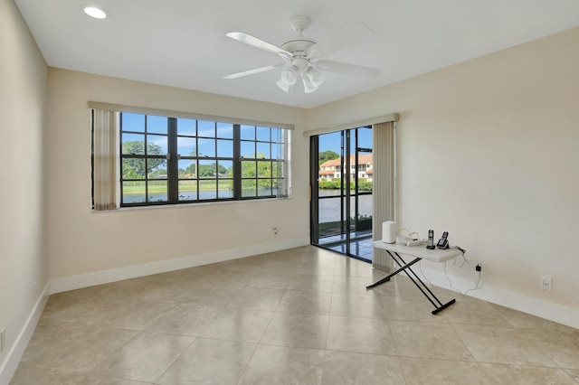 tiled spare room with ceiling fan