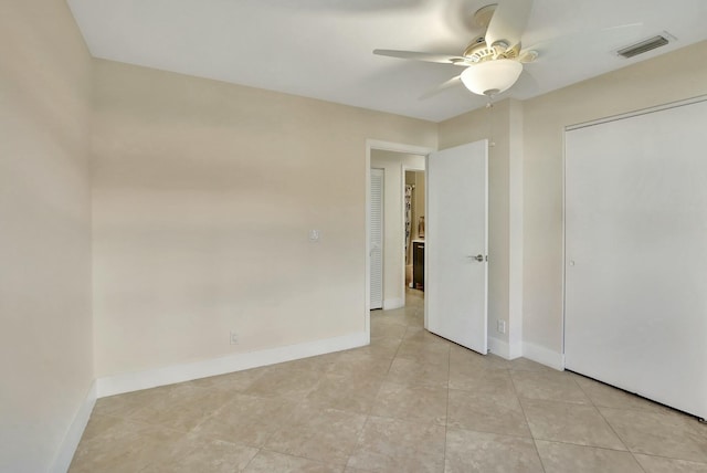 unfurnished bedroom featuring ceiling fan, light tile patterned floors, and a closet