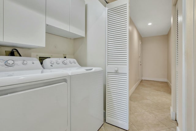 laundry area featuring cabinets, independent washer and dryer, and light tile patterned floors