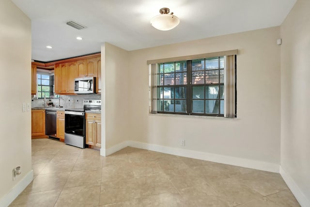 kitchen featuring sink, stainless steel appliances, tasteful backsplash, and light tile patterned flooring