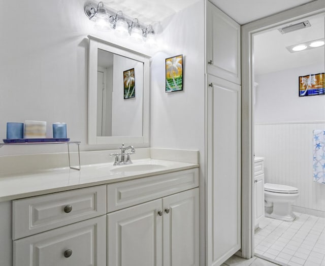 bathroom with tile patterned flooring, vanity, and toilet