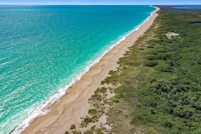 drone / aerial view featuring a water view and a beach view