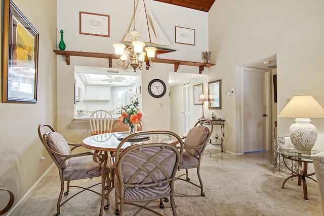 dining area with light colored carpet, a high ceiling, and a chandelier