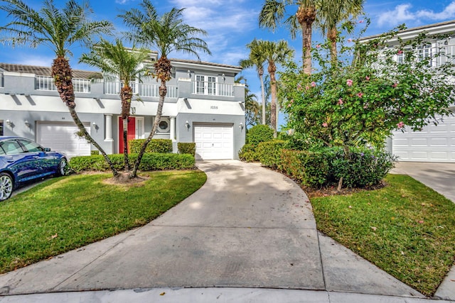 view of front of house featuring a front yard, a balcony, and a garage