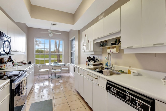 kitchen with sink, light tile patterned floors, dishwasher, white cabinetry, and stainless steel electric range