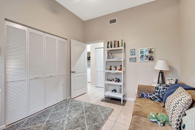 interior space with a towering ceiling, washer / clothes dryer, and light tile patterned flooring