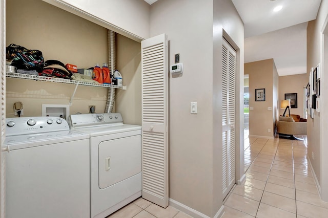 laundry room featuring washing machine and dryer and light tile patterned flooring