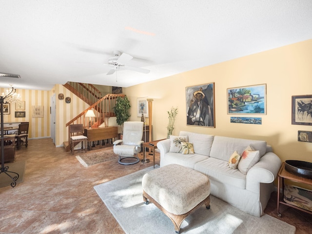 living room featuring a textured ceiling and ceiling fan with notable chandelier