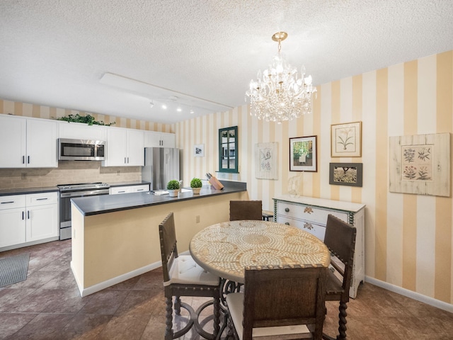 dining area featuring a textured ceiling, rail lighting, and a notable chandelier