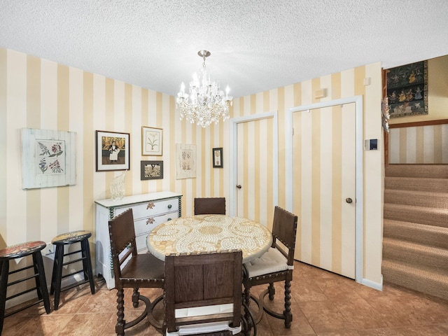 tiled dining room with a notable chandelier and a textured ceiling