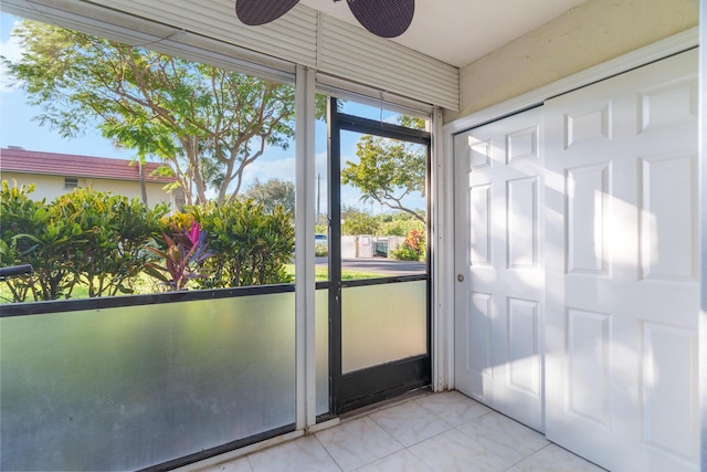 unfurnished sunroom featuring ceiling fan