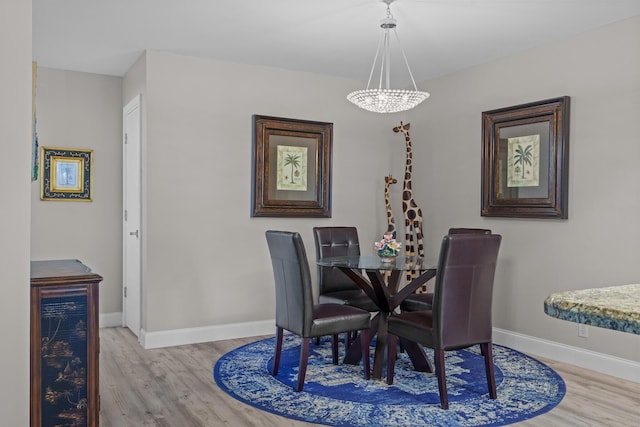 dining room with a chandelier and light wood-type flooring