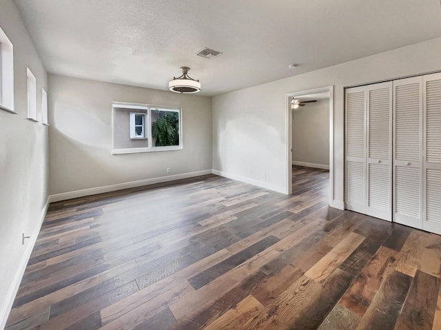 unfurnished bedroom featuring a closet and dark hardwood / wood-style flooring