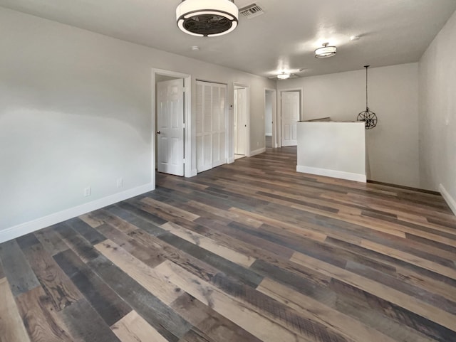 empty room with dark hardwood / wood-style floors and ceiling fan