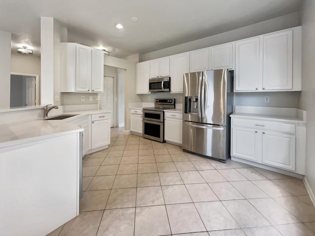 kitchen with white cabinets, light tile patterned floors, stainless steel appliances, and sink