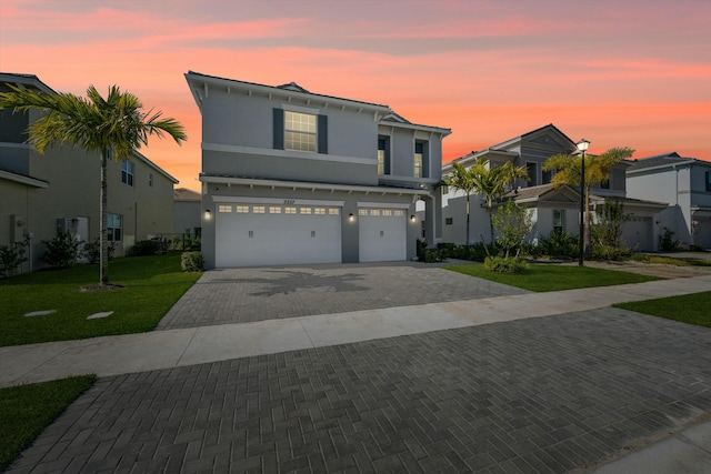 view of front of home with a yard and a garage