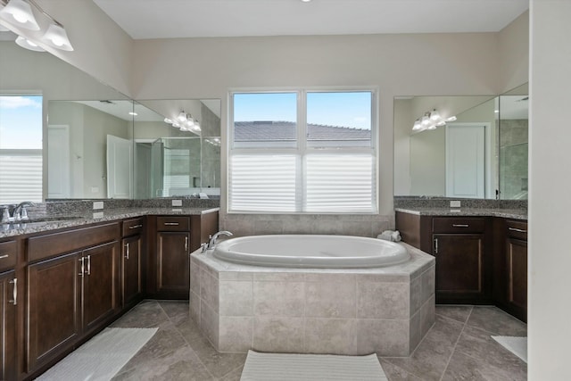 bathroom featuring tile patterned floors, tiled bath, and vanity