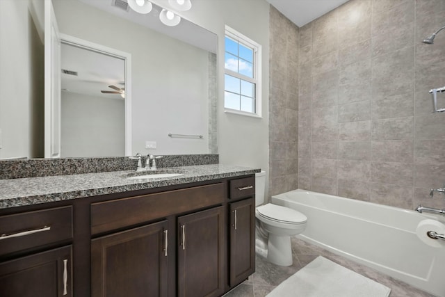 full bathroom with vanity, tile patterned floors, ceiling fan, tiled shower / bath combo, and toilet