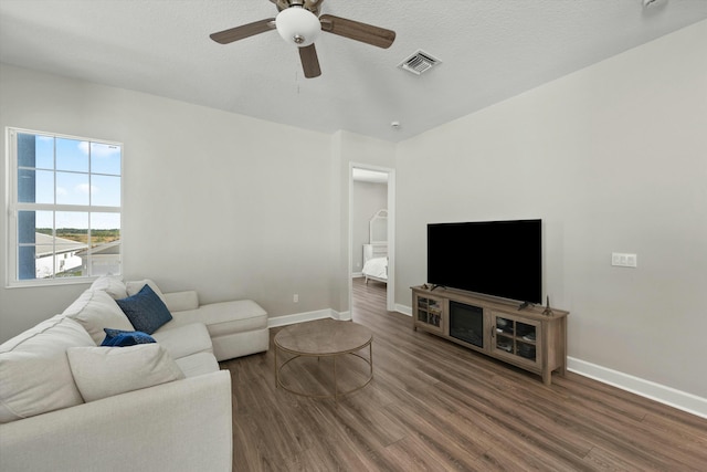 living room with ceiling fan and dark hardwood / wood-style flooring