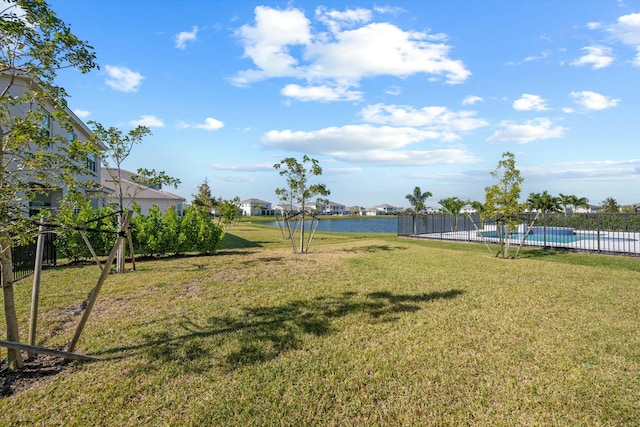 view of yard with a fenced in pool and a water view