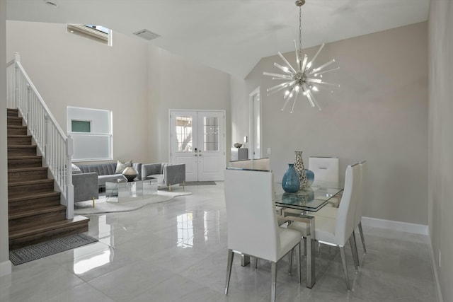 dining space with a towering ceiling and a notable chandelier