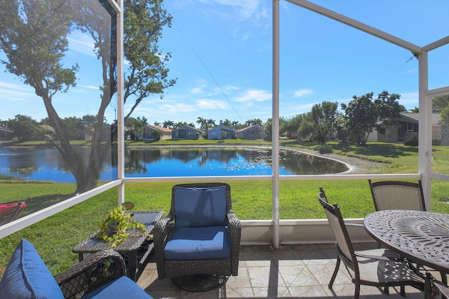 sunroom featuring a water view