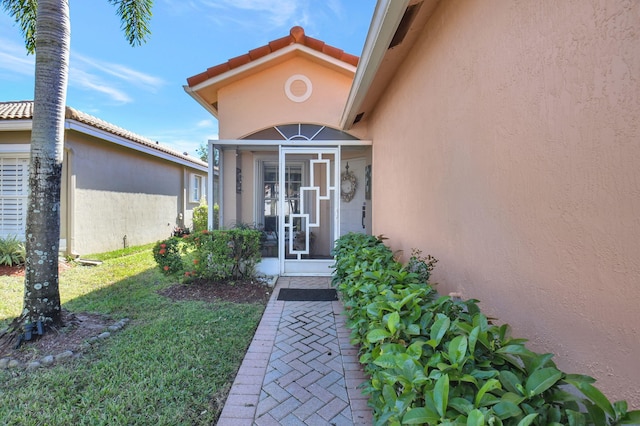 doorway to property with a lawn