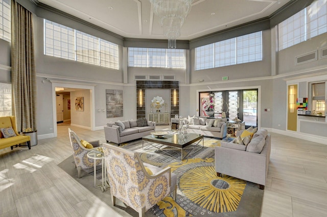 living room featuring french doors, a towering ceiling, and a notable chandelier