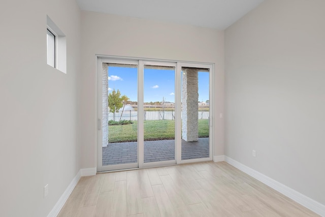 interior space with a water view and light hardwood / wood-style flooring