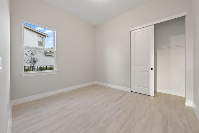 unfurnished bedroom with light hardwood / wood-style flooring and a closet