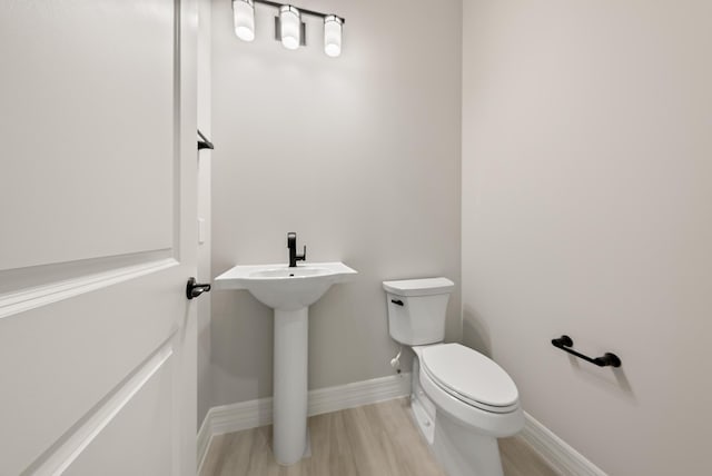 bathroom featuring wood-type flooring and toilet