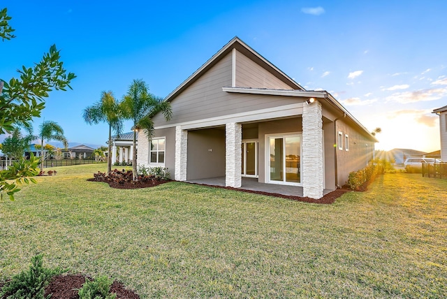 rear view of property with a yard and a patio