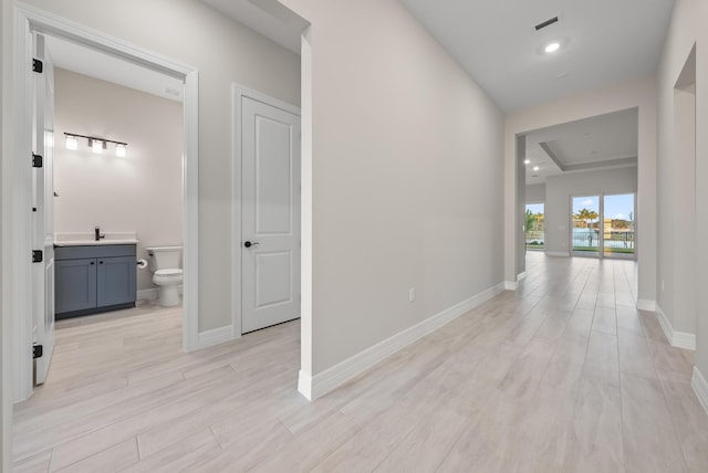 corridor featuring sink and light hardwood / wood-style floors