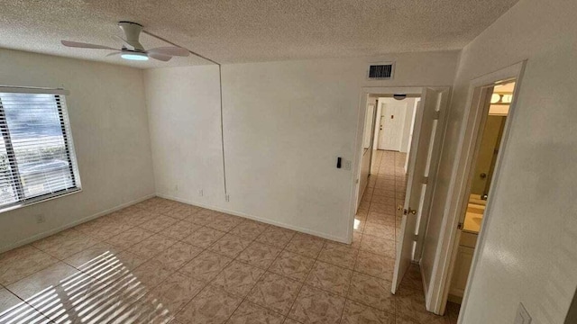 spare room featuring a textured ceiling and ceiling fan