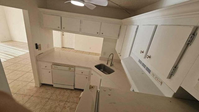 kitchen featuring light tile patterned floors, white dishwasher, white cabinetry, and sink