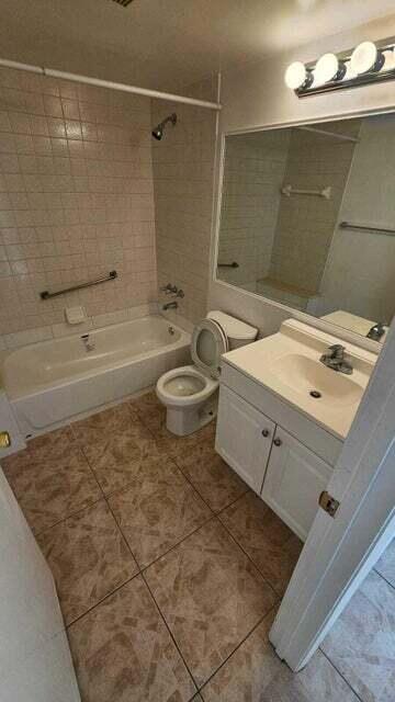 full bathroom with tile patterned floors, vanity, toilet, and tiled shower / bath