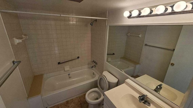 full bathroom with vanity, tiled shower / bath combo, and toilet