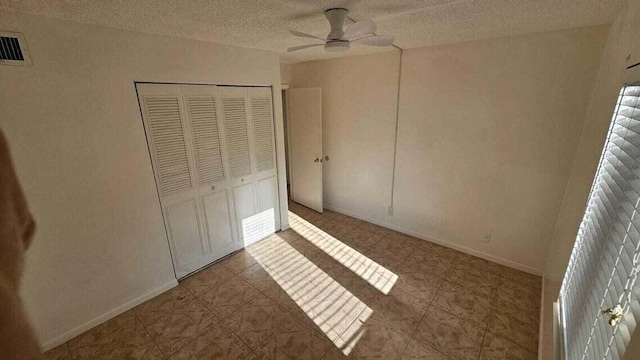 unfurnished bedroom featuring a textured ceiling, a closet, and ceiling fan