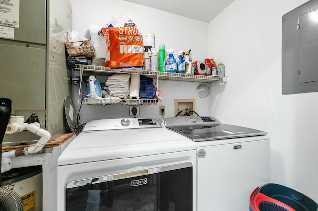 washroom with washer and clothes dryer, a textured ceiling, and electric panel