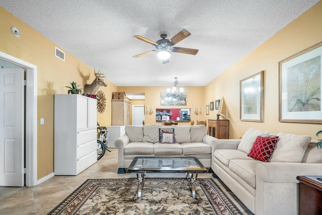 living room featuring ceiling fan with notable chandelier and a textured ceiling