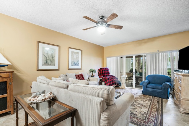 living room with ceiling fan and a textured ceiling